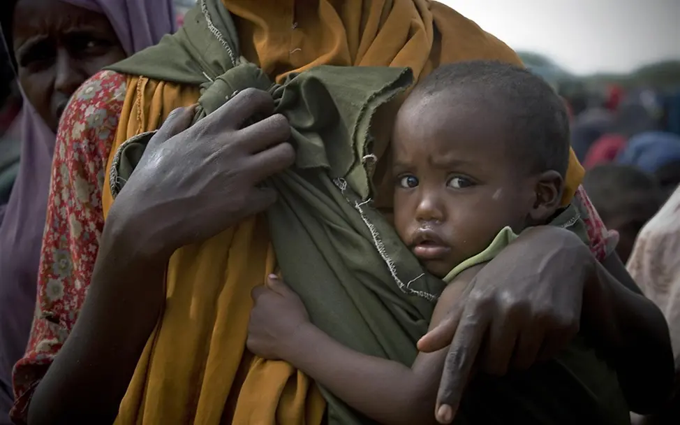 Ein Kind wartet mit seiner Mutter auf die Verteilung von Lebensmitteln. ©UNICEF/Holt Ein Kind wartet mit seiner Mutter auf die Verteilung von Lebensmitteln. ©UNICEF/Holt