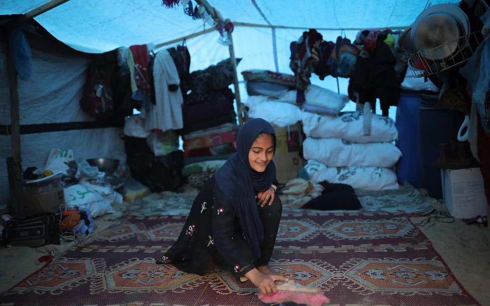 Ein junges Mädchen auf dem Boden ihres Zeltes in Rafah