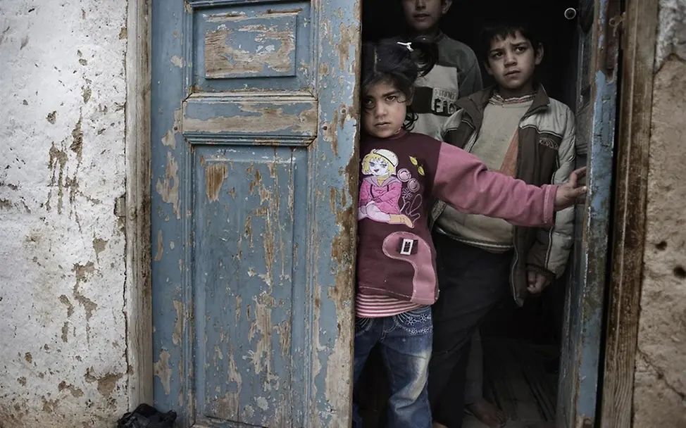 Kinder suchen in einem Türeingang Schutz vor den Gefechten. ©UNICEF/Romenzi Kinder suchen in einem Türeingang Schutz vor den Gefechten. ©UNICEF/Romenzi