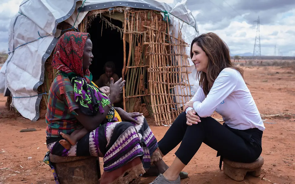 Tessa Page im Gespräch | © UNICEF/UN0724770/Ayene Tessa Page im Gespräch mit einer Frau die ein Kind auf dem Arm hält