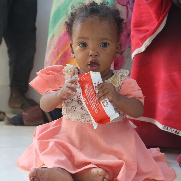 A small child in Sudan gets feed with nutricious peanut paste to fight the malnutrition