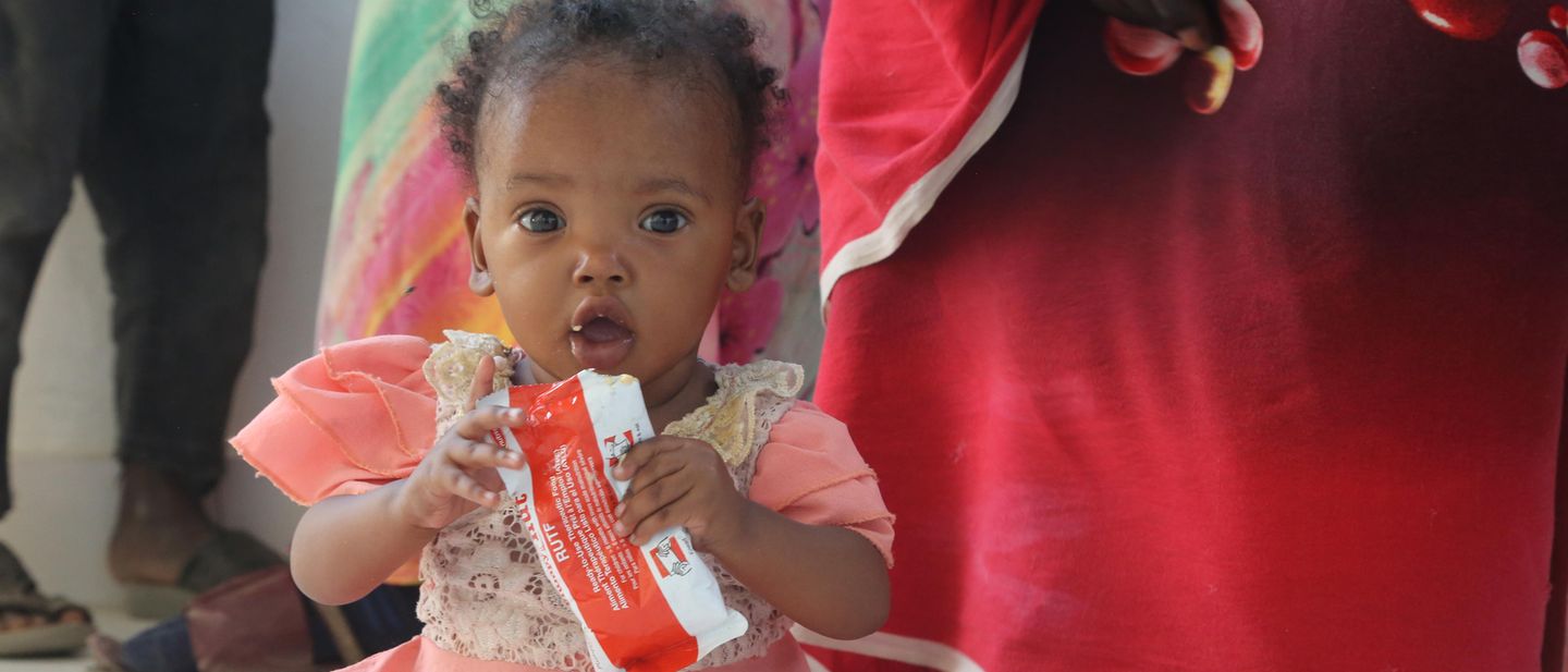 A small child in Sudan gets feed with nutricious peanut paste to fight the malnutrition