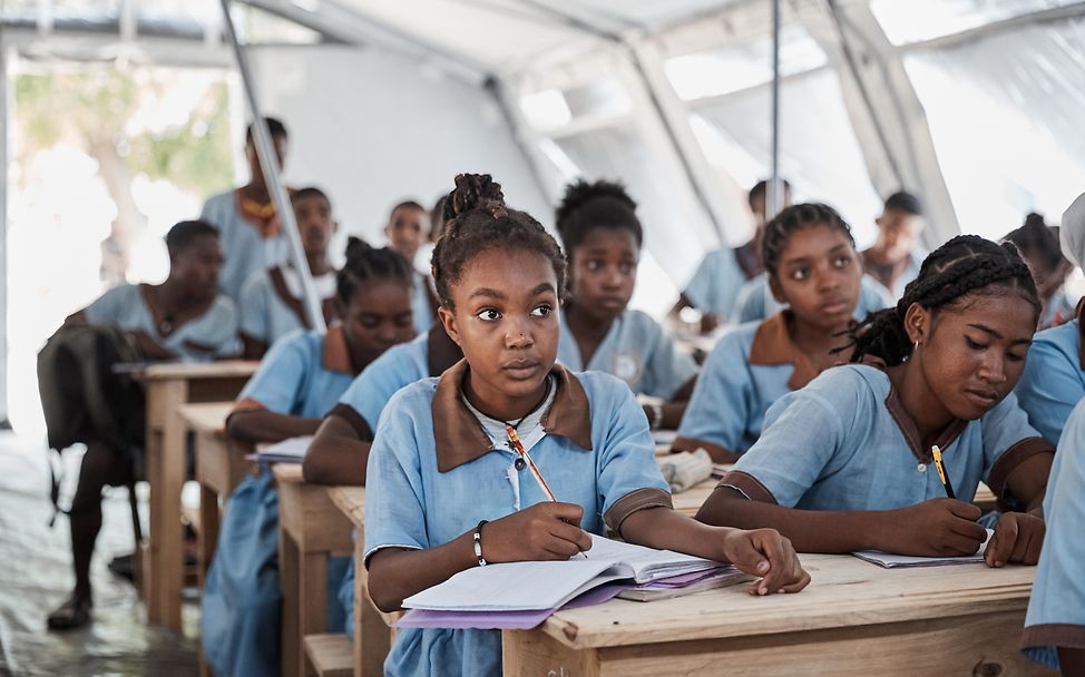 Jugendliche sitzen in der Schule in Madagaskar und schreiben mit