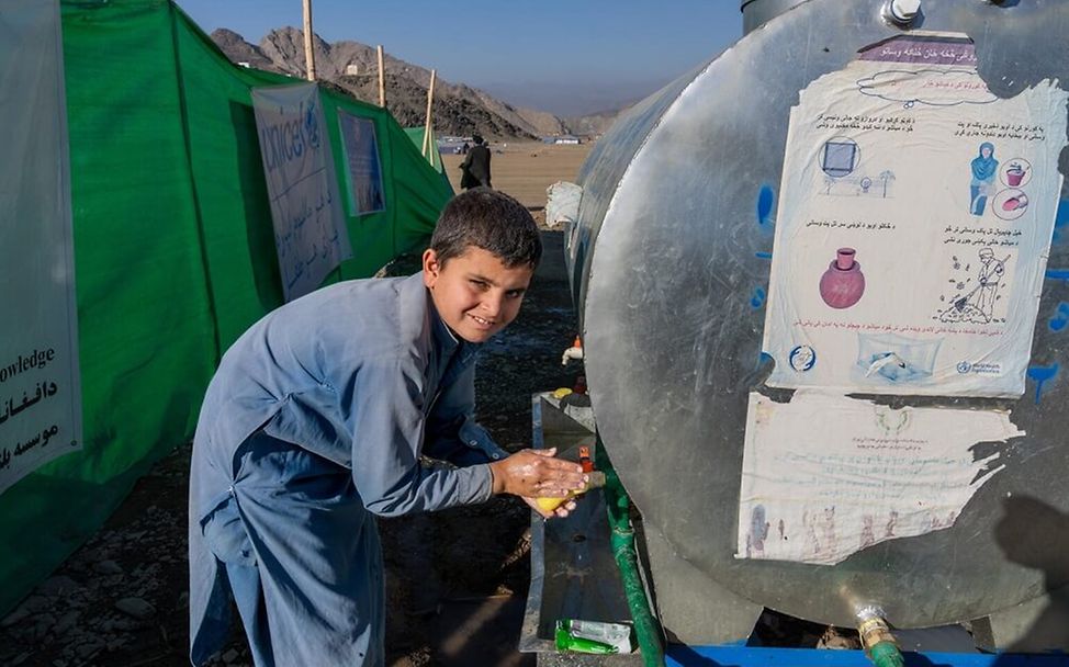 Masern: Ein Junge holt Wasser aus einem UNICEF-Tank. Sauberes Wasser hilft, Krankheiten vorzubeugen