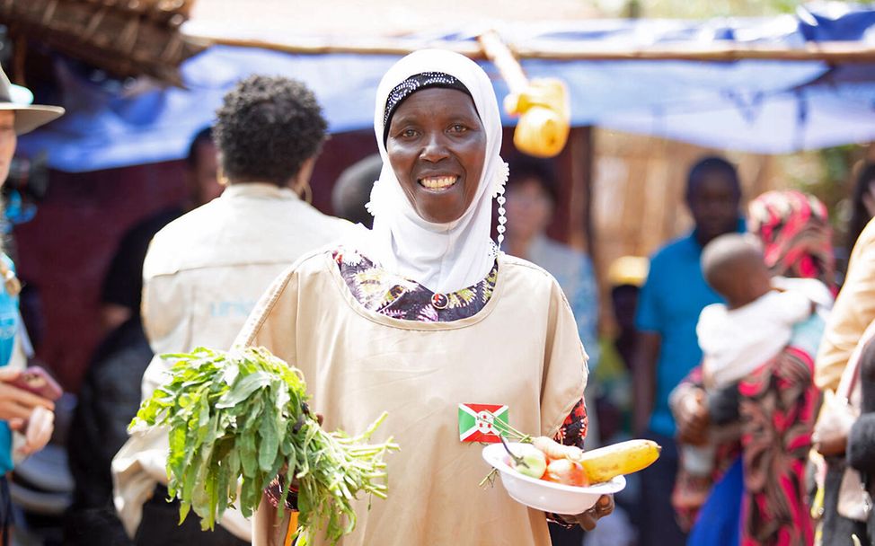 Burundi Hunger bekämpfen: Eine Ernährungshelferin erklärt Familien, wie sie ihre Kinder gesund ernähren können. 