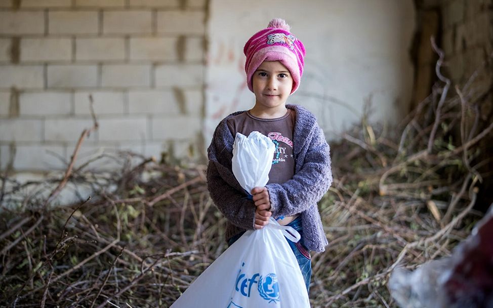 Libanon Kinder: Ein Junge hält eine Tüte mit UNICEF-Hilfsgütern in der Hand