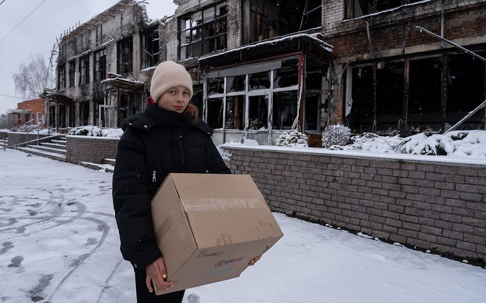 Ukraine: Sofia trägt ein Winterhilfe-Paket von UNICEF durch den Schnee