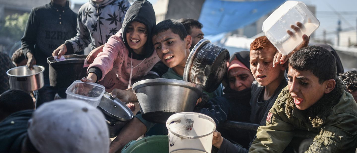 Kinder stehen Schlange, um eine kleine Menge Essen in der Stadt Rafah im Süden des Gazastreifens zu erhalten. 