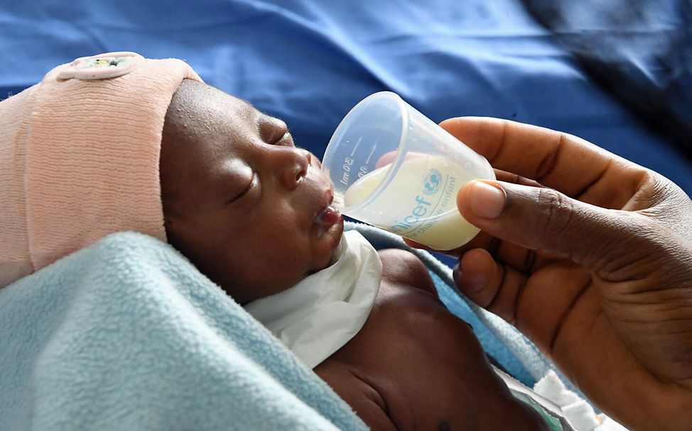 Originelle Geschenkideen für einen guten Zweck: Ein Baby wird an der Elfenbeinküste mit Spezialmilch von UNICEF gefüttert