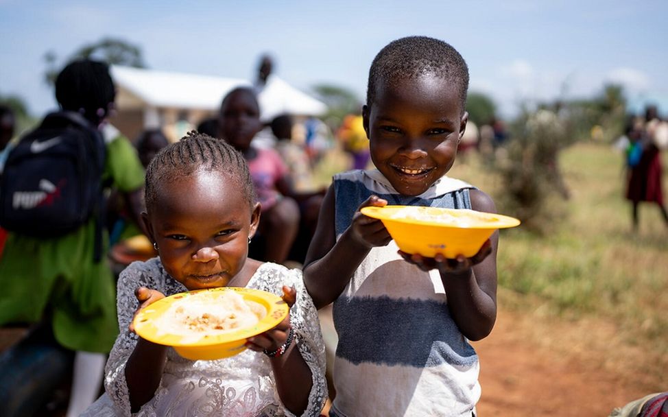 Gesunde Ernährung für Kinder in Uganda: Zwei Kinder essen aus der complementary feeding bowl von UNICEF