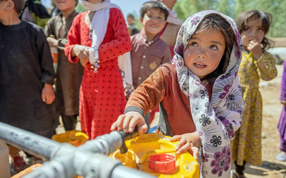 Wasser spenden: Ein Mädchen in Afghanistan befüllt einen Wasserkanister mit frischem Trinkwasser 