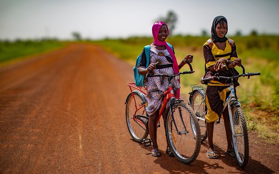 Hawa und Koumba, 15 Jahre alt, mit dem Fahrrad unterwegs zu ihrer Schule.