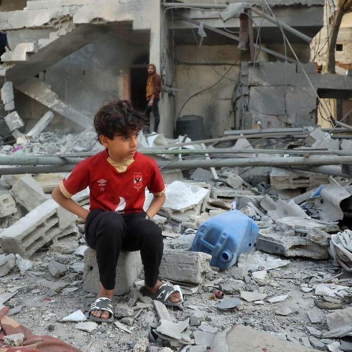 Gaza spenden: Ein Junge sitzt nach Luftangriffen in den Trümmern seines Zuhauses