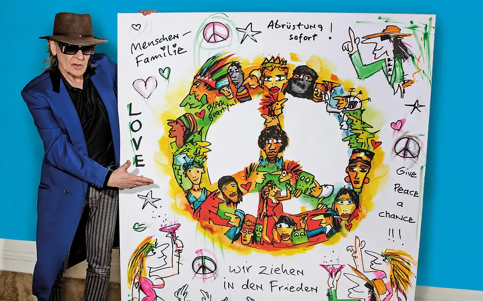 UNICEF-Botschafter Udo Lindenberg mit einem Kunstwerk mit Friedensmotiven. | © Tine Acke Udo Lindenberg mit einem Antikriegskunstwerk.