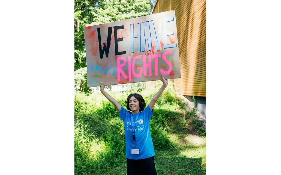 "We have rights" auf dem UNICEF Youth Festival | © UNICEF/Stroisch Kind hält "We have rights" Schild.