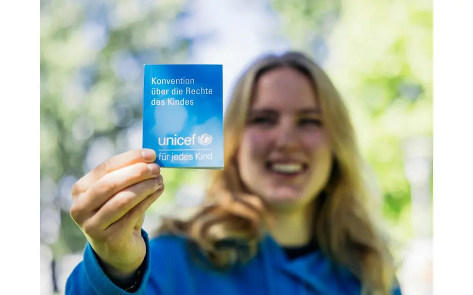 UNICEF Youth Festival | © UNICEF/Stroisch Teilnehmerin zeigt UNICEF Flyer.