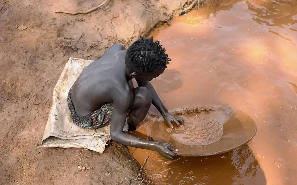 Ein Junge in Äthiopien schürft an einer Wasserstelle nach Gold | © UNICEF/Bizuwerk Kinderarbeit stoppen: Ein Junge in Äthiopien schürft an einer Wasserstelle nach Gold.