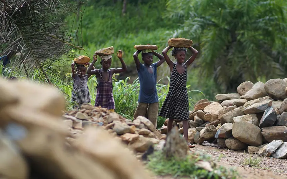 Arbeitende Kinder in einem Steinbruch in Sierra Leone tragen Steine auf ihren Köpfen. | © UNICEF/Songa Kinderarbeit stoppen: Arbeitende Kinder in einem Steinbruch in Sierra Leone tragen Steine auf ihren Köpfen.