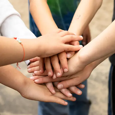 Jugendliche engagieren sich für UNICEF |© UNICEF/Etges Bild von übereinandergelegten Kinderhänden.