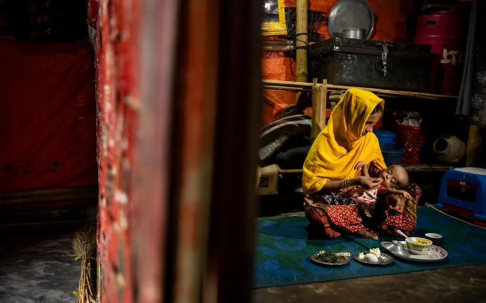 Rohingya in Cox's Bazar | © UNICEF/UNI622136/Njiokiktjien Eine junge Frau füttert ihr Baby