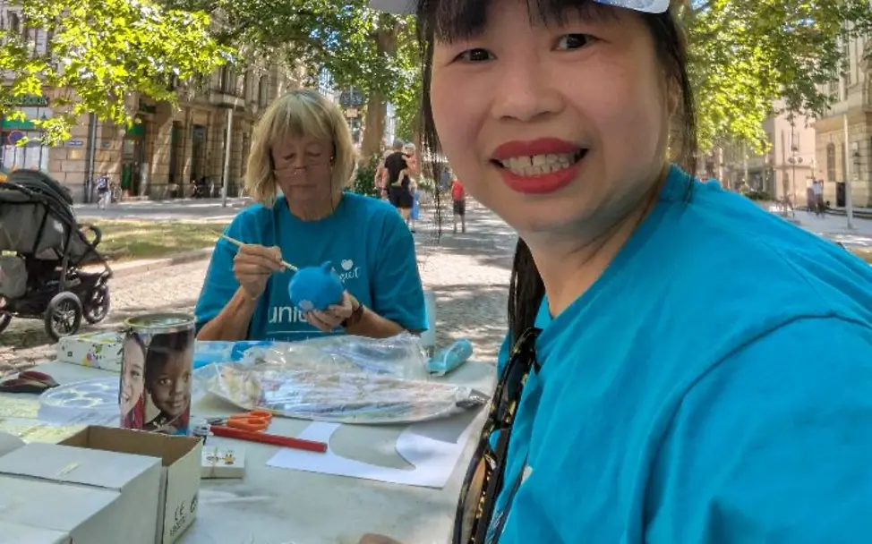 Zwei Frauen aus der UNICEF-AG Dresden sitzen am Stand mit Malsachen und Infos zu Kinderrechten