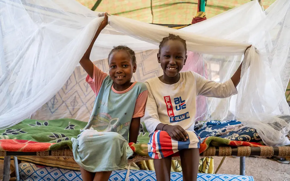 Spenden Sudan Nothilfe: Zwei aus Khartum geflohene Geschwister sitzen unter einem Moskitonetz. 