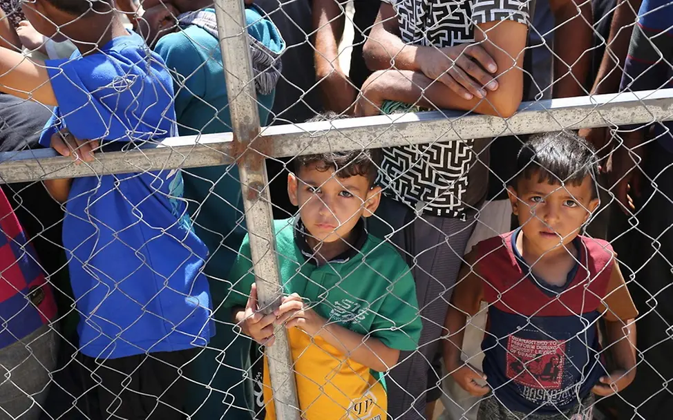 Kinder warten geduldig, hungrig und erschöpf auf Essen.