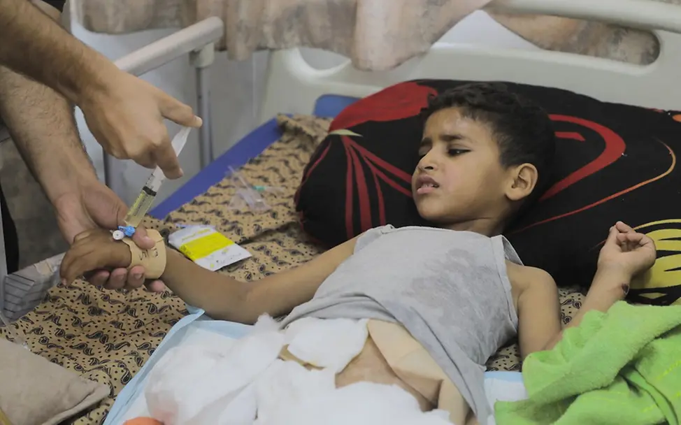 Sanad (10) nach der Amputation seines rechten Beins im Krankenhaus. 