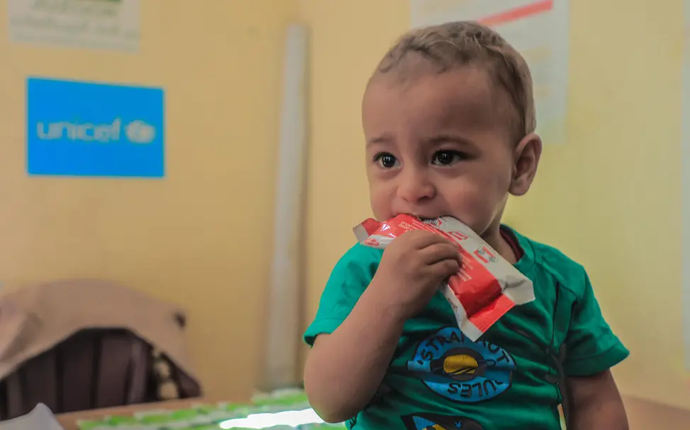 A child receives therapeutic food from UNICEF | © UNICEF/UNI809866/Nateel A small child eats therapeutic peanut paste against malnutrition