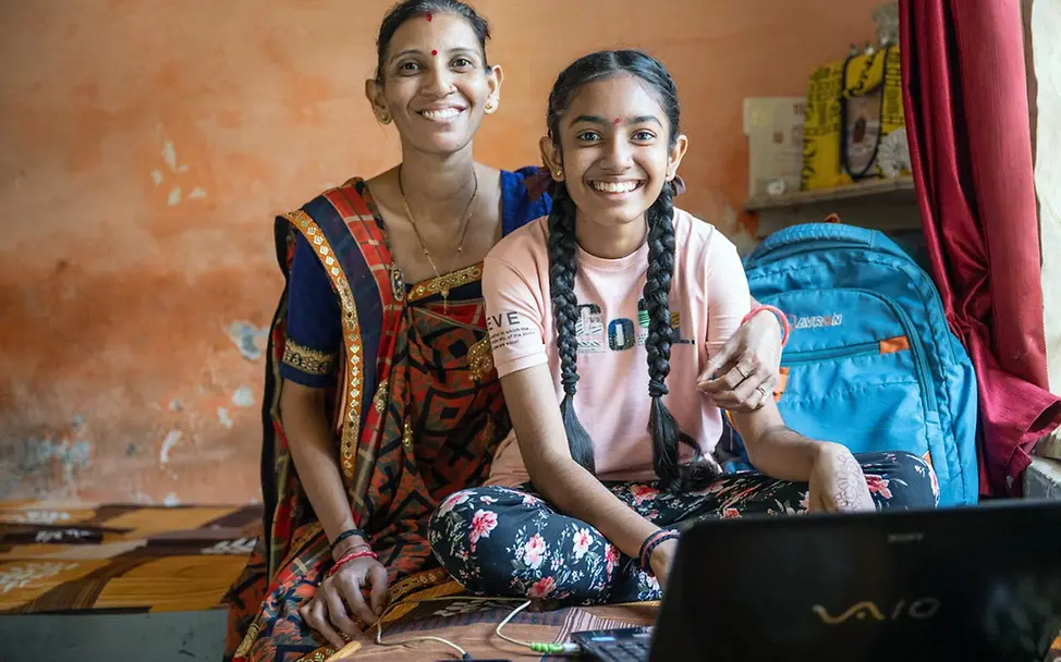 Digitale Gewohnheiten: Ein Mädchen in Indien sitzt mit ihrer Mutter zuhause an einem Laptop. 