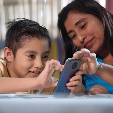 Digitale Gewohnheiten: Ein Junge in Ecuador zeigt seiner Mutter etwas am Smartphone. 