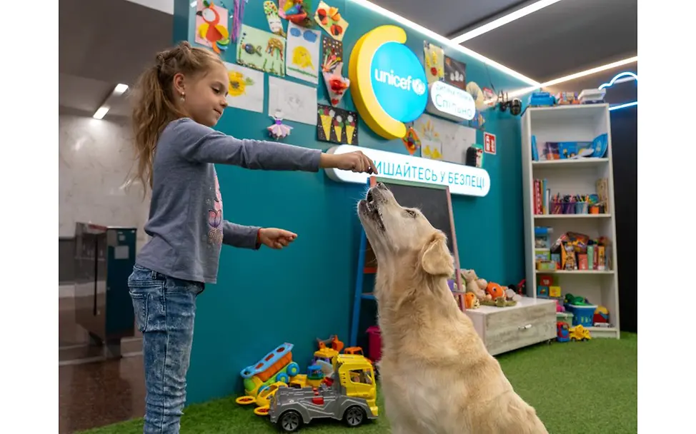 © UNICEF/Meerzad  Ukraine: Mädchen spielt mit Hund.