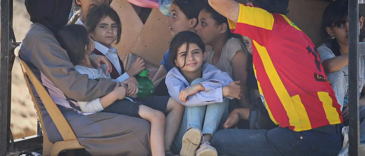 Eine Familie mit Kindern auf der Ladefläche eines Trucks