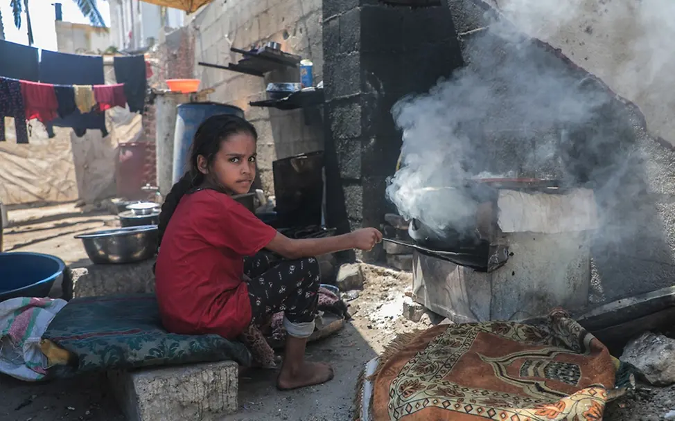Hunger in Gaza | UNICEF/Nateel Gaza: Die elfjährige Rafif sitzt vor einem provisorischem Ofen