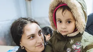 Ukraine: Kind erhält Winterkleidung.