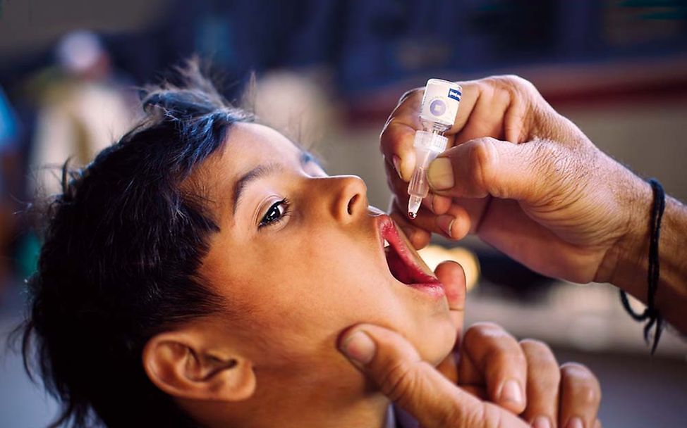 Schluckimpfung schützt vor Polio: Ein Junge aus Pakistan wird geimpft