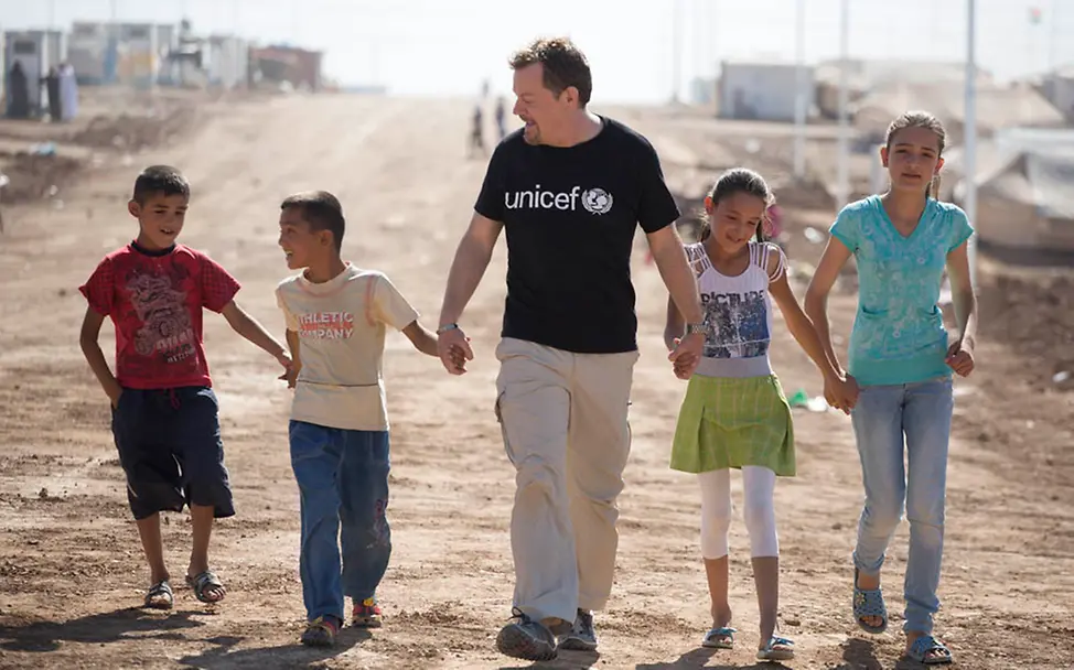UNICEF-Botschafter Eddie Izzard mit syrischen Flüchtlingskindern | © UNICEF UK UNICEF Jahresrückblick 2014