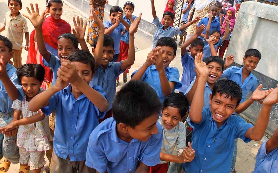 Spenden für Bildung: Schulkinder in Bangladesch winken fröhlich. 